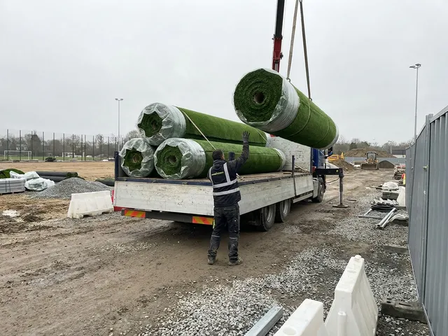 Разгрузка рулонов травы на объекте